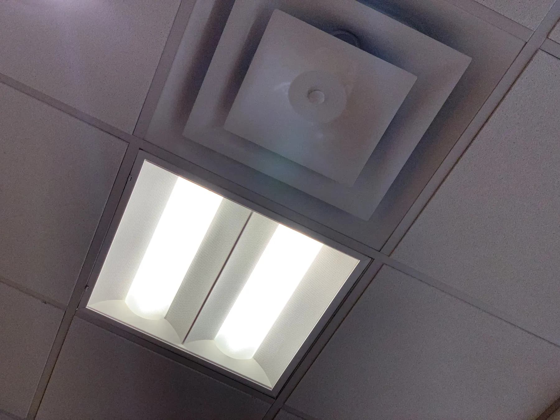 Ceiling supply vent and light panel in a clean modern interior